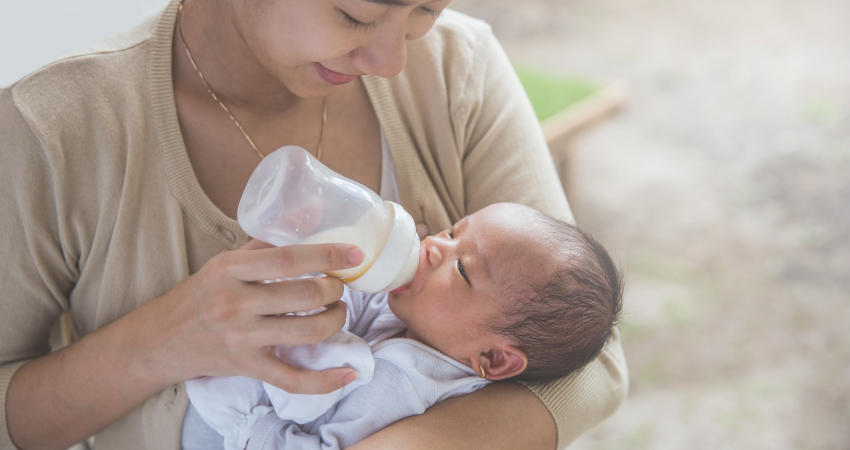 Asian mom feeding baby bottle